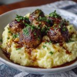 Salisbury steak meatballs served over garlic herb mashed potatoes with rich brown gravy.
