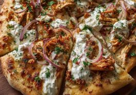 Cajun shrimp and chicken pizza drizzled with creamy tzatziki sauce and garnished with fresh herbs.
