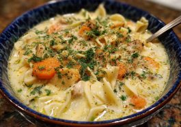 “A steaming bowl of Amish snow day soup filled with noodles, vegetables, and tender chicken, served with rustic bread.”