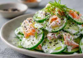 Creamy cucumber salad with sesame seeds and herbs served in a bowl.