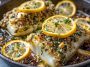 Gluten-free Mediterranean baked cod fillet with lemon slices, garlic, and fresh herbs served on a rustic platter.