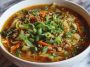 Bowl of healthy egg roll soup with ground turkey, cabbage, carrots, and green onions in a savory broth.
