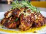 “Golden crispy lemon pecorino chicken served on a plate with fresh herbs and lemon wedges.”