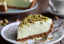 Slice of pistachio cream pie topped with whipped cream and crushed pistachios.