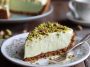Slice of pistachio cream pie topped with whipped cream and crushed pistachios.