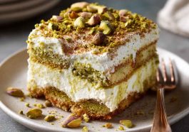 "Elegant pistachio tiramisu layered with mascarpone cream, ladyfingers, and crushed pistachios, served in a glass dish."