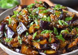 Sautéed Chinese eggplant in garlic sauce, tender eggplant pieces coated in savory, glossy sauce with sesame seeds and scallions.