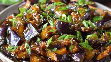 Sautéed Chinese eggplant in garlic sauce, tender eggplant pieces coated in savory, glossy sauce with sesame seeds and scallions.