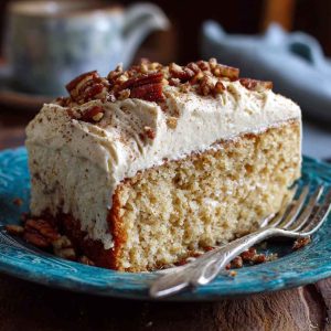 Butter pecan tres leches cake topped with whipped cream, caramel drizzle, and crunchy pecans, served moist and decadent.