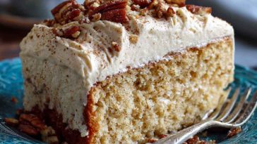 Butter pecan tres leches cake topped with whipped cream, caramel drizzle, and crunchy pecans, served moist and decadent.