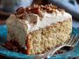 Butter pecan tres leches cake topped with whipped cream, caramel drizzle, and crunchy pecans, served moist and decadent.