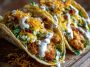 Smash chicken tacos topped with dill pickle ranch and wrapped in crispy cheese lace shells.