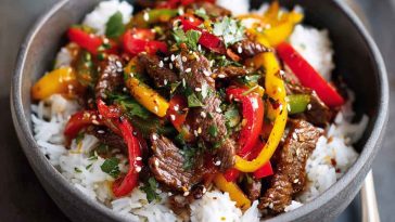 Healthy beef and pepper rice bowl with tender beef strips, colorful bell peppers, fluffy rice, and a light savory sauce served in a bowl.