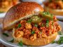 "Easy Cajun chicken sloppy joes served on toasted buns with spicy Cajun seasoning, melted cheese, and fresh parsley garnish."