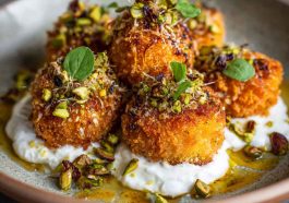 Golden sweet potato croquettes served with burrata dip and sprinkled with pistachio crunch.
