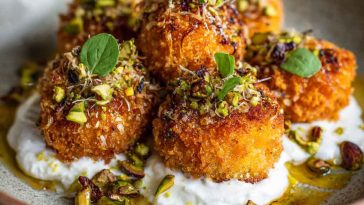 Golden sweet potato croquettes served with burrata dip and sprinkled with pistachio crunch.