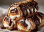 Golden s’mores roll-ups filled with gooey marshmallows, melted chocolate, and graham cracker crumbs, served warm on a plate.