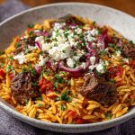 “A traditional Greek beef giouvetsi with tender beef, orzo pasta, rich tomato sauce, and sprinkled cheese.”