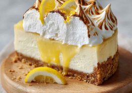 Triple lemon meringue cheesecake with golden crust, creamy lemon filling, and fluffy toasted meringue topping.