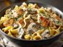 Creamy chicken stroganoff served over egg noodles, garnished with fresh parsley and mushrooms in a rich sauce.