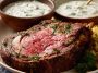 “A creamy bowl of Ina Garten’s horseradish sauce served alongside slices of prime rib roast.”