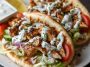 “Warm pita bread filled with juicy Mediterranean chicken gyros, fresh vegetables, and creamy tzatziki sauce.”