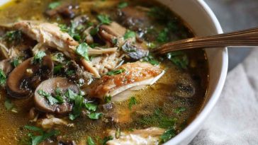 Cozy bowl of rotisserie chicken and mushroom soup, hearty fall comfort food with fresh herbs.
