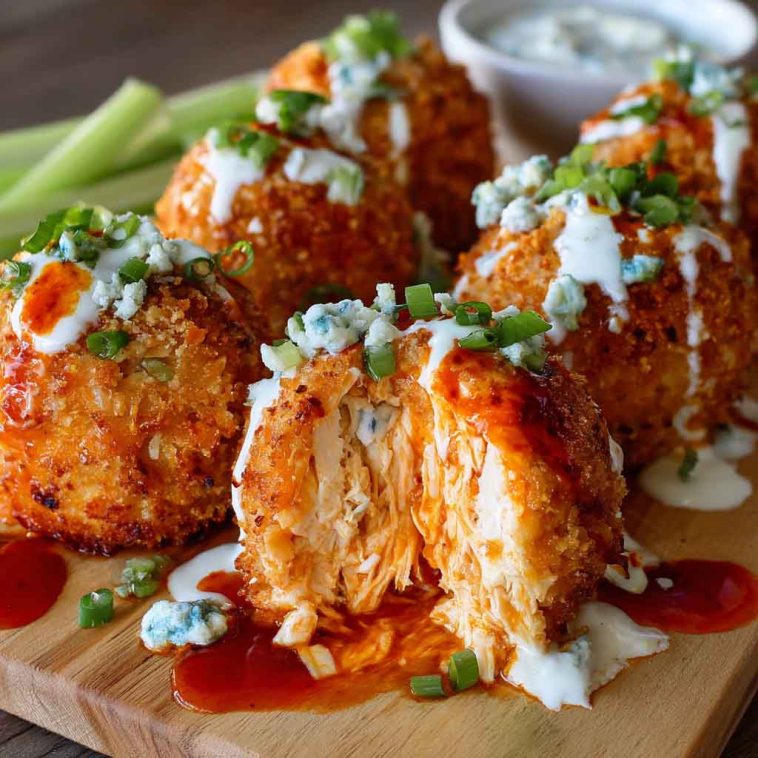Golden buffalo chicken bombs stuffed with spicy shredded chicken, cream cheese, and melted cheddar, drizzled with buffalo sauce and served warm.