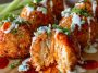 Golden buffalo chicken bombs stuffed with spicy shredded chicken, cream cheese, and melted cheddar, drizzled with buffalo sauce and served warm.