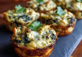 "Mini spinach and artichoke dip cups baked in golden phyllo shells, topped with melted cheese and fresh herbs."