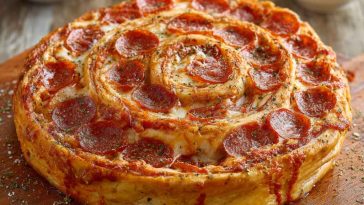 “A golden-brown jumbo pepperoni-stuffed pizza spiral sliced into rounds, oozing with melted cheese and served on a platter.”