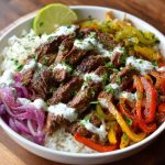 “A colorful steak fajita bowl with grilled steak strips, sautéed peppers, onions, avocado, and cauliflower rice.”