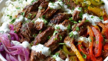 “A colorful steak fajita bowl with grilled steak strips, sautéed peppers, onions, avocado, and cauliflower rice.”