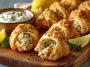 Golden crescent bites filled with creamy crab and cheese, served on a platter with parsley garnish.