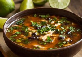 Bowl of chicken poblano and black bean soup with tender chicken, roasted poblano peppers, black beans, corn, and fresh cilantro garnish.
