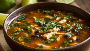 Bowl of chicken poblano and black bean soup with tender chicken, roasted poblano peppers, black beans, corn, and fresh cilantro garnish.