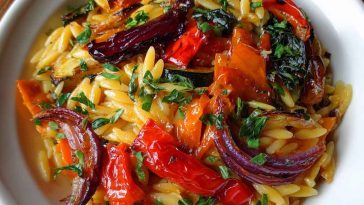 Roasted vegetable orzo served in a bowl, featuring golden roasted zucchini, bell peppers, cherry tomatoes, and tender orzo pasta tossed with olive oil and fresh herbs.
