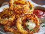 Crispy keto onion rings baked until golden brown, coated without breadcrumbs or frying, served with a creamy low-carb dipping sauce.