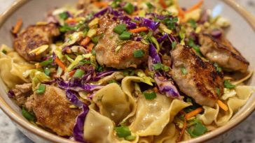 Potsticker noodle bowl with pork, noodles, and fresh cabbage slaw served in a bowl.