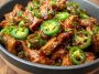 Irresistible sweet jalapeño pork served in a skillet with tender pork pieces glazed in a sweet and spicy jalapeño sauce, garnished with fresh cilantro and lime wedges.