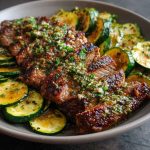Effortless garlic butter steak and zucchini delight served in a skillet with juicy seared steak bites, sautéed zucchini, and a rich garlic butter sauce, garnished with fresh parsley.