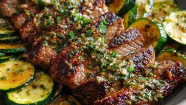 Effortless garlic butter steak and zucchini delight served in a skillet with juicy seared steak bites, sautéed zucchini, and a rich garlic butter sauce, garnished with fresh parsley.
