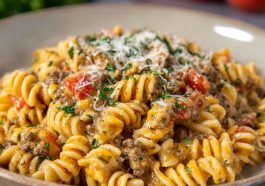 Creamy Rotel pasta with ground beef served in a skillet, featuring tender pasta coated in a cheesy Rotel tomato sauce with seasoned ground beef, garnished with fresh parsley.