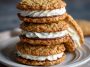 Homemade oatmeal cream pies with soft, chewy oatmeal cookies sandwiched together with a fluffy vanilla cream filling, stacked on a plate for serving.