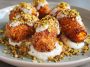 Golden sweet potato croquettes served on a platter with creamy burrata dip, topped with crushed pistachios and fresh herbs, arranged elegantly for a gourmet appetizer.
