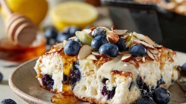High-protein lemon blueberry breakfast bake made with cottage cheese, fresh blueberries, oats, and a golden crust, served warm in a baking dish and garnished with lemon zest.