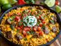 Bowl of steak queso rice topped with melted cheese and garnished with fresh cilantro.