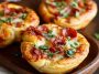 Mini deep dish crescent roll pizzas baked in muffin tins, filled with marinara sauce, melted mozzarella, and pepperoni, served hot and golden brown.