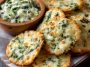 Spinach dip cheese crisps baked until golden and crunchy, topped with melted cheese and spinach, served on a tray as bite-sized appetizers.