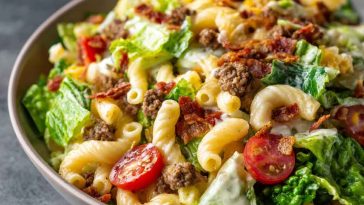Big Mac Pasta Salad with ground beef, cheddar cheese, lettuce, pickles, and creamy special sauce in a colorful bowl.